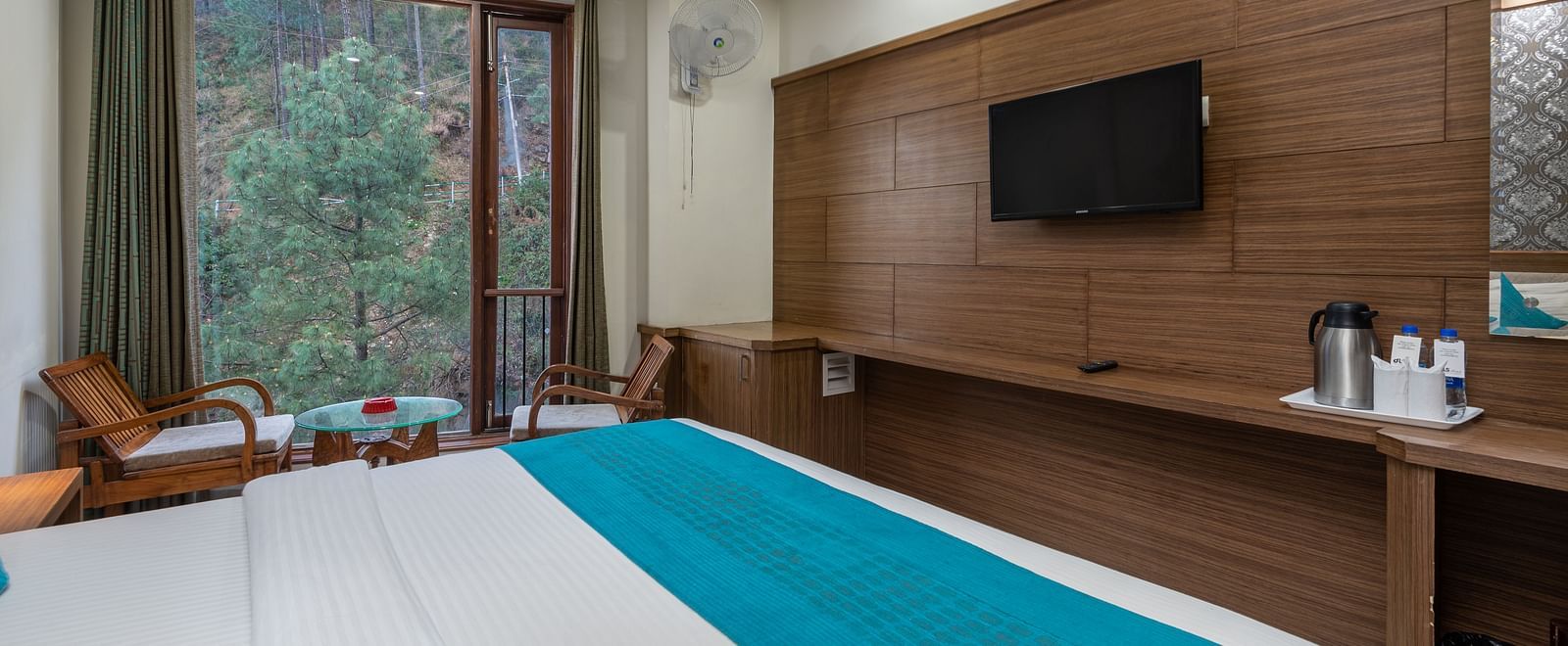 A bedroom featuring a seating area with a table and two chairs near the window at DLS Hotels The Rock Castle.